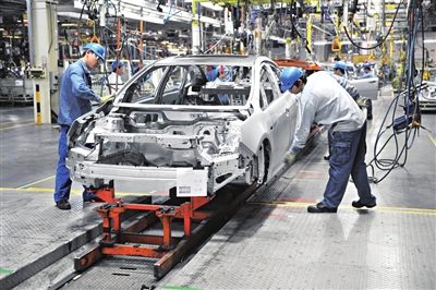 通用汽车生产线上,工人正在组装汽车